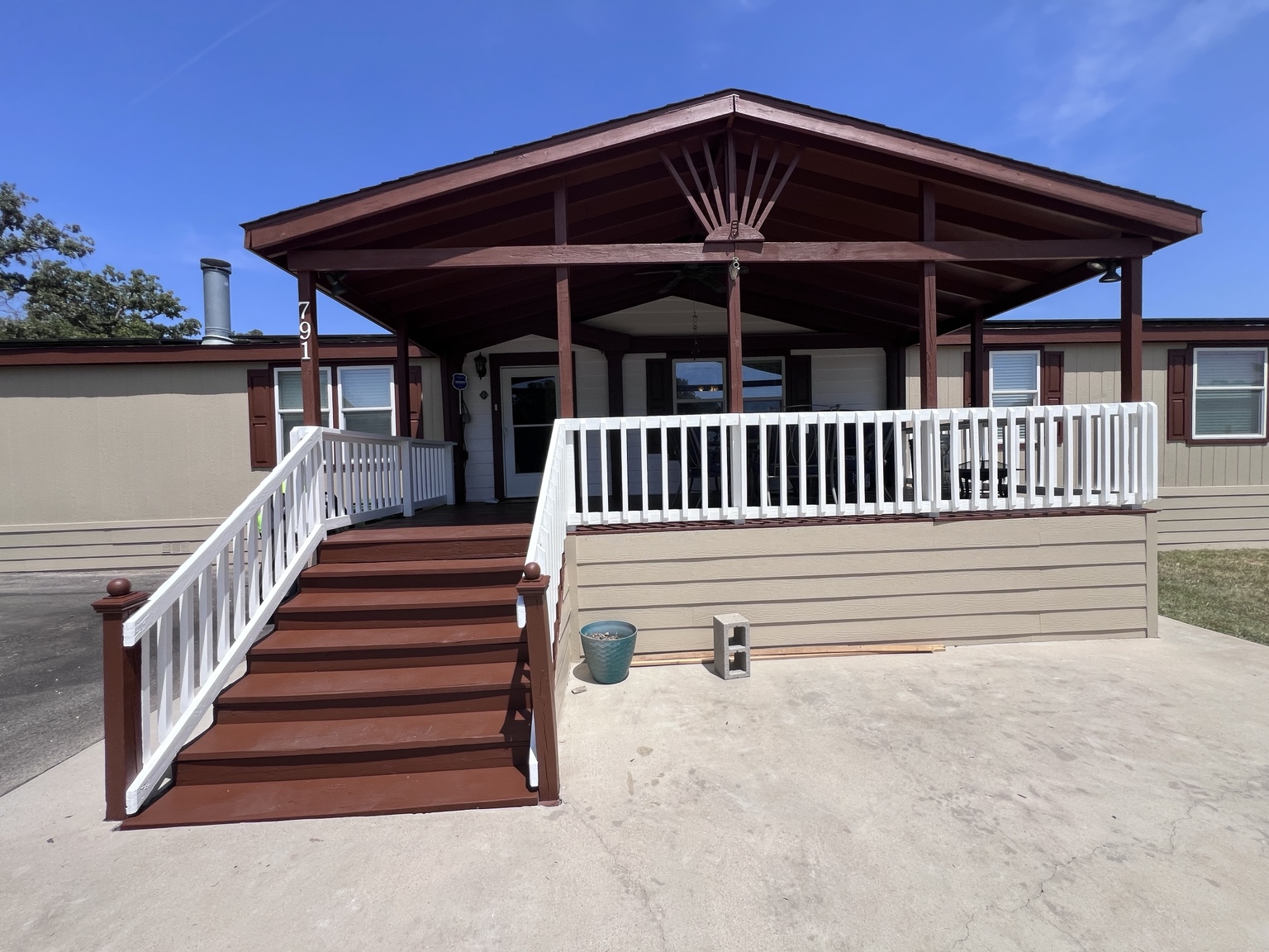 Close view of the finished porch with stained gable ceiling, painted white railings and stained stairs completed by N&M Services.